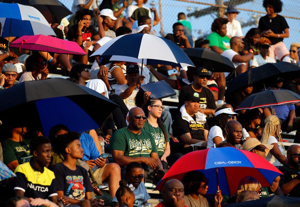 Desoto fans shield themselves various ways from the hot summer sun during the first half of...