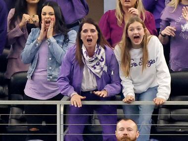 TCU Horned Frogs head coach Sonny Dykes’ wife Kate Golding (leaning on riling in purple...