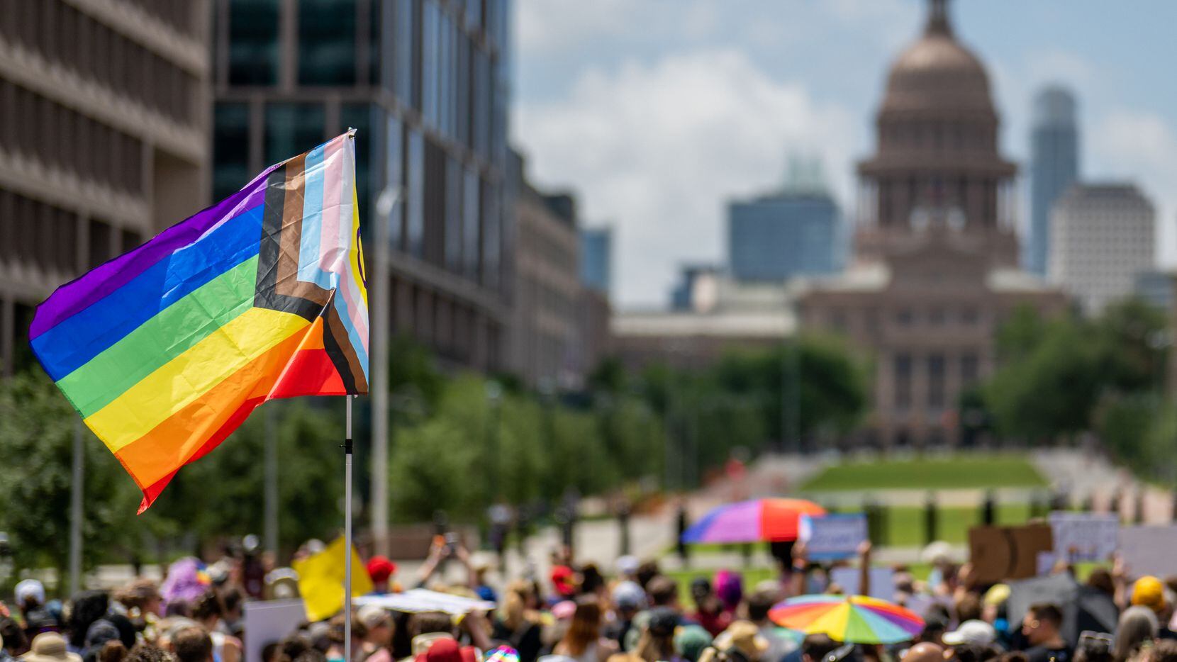 A pride flag is seen held up in a crowd during preparation for a Queer March to the Texas...