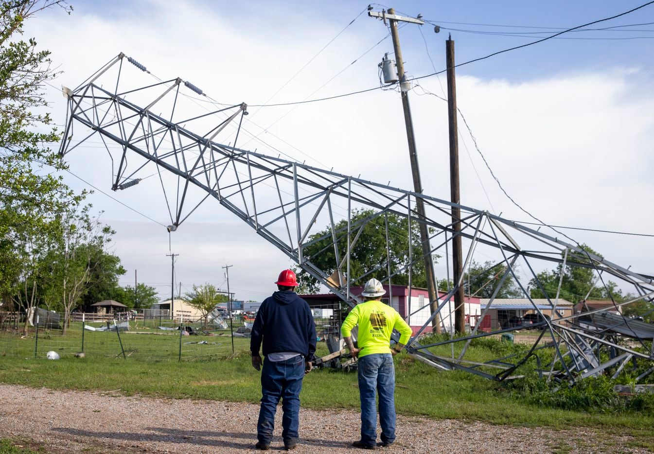 Oncor personnel survey a downed power structure where a Monday night tornado touched down just south of Waxahachie, Texas, on Tuesday, May 4, 2021. (Lynda M. González/The Dallas Morning News)