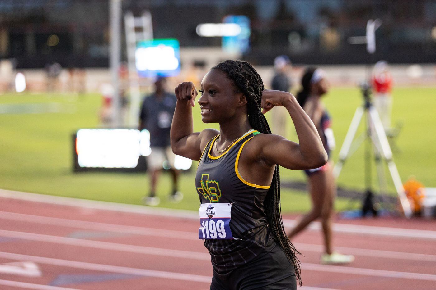 Aniyah Bigam of Carrollton Smith poses with arms flexed after the girls’ 200m dash at the...