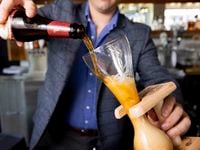 Owner Jeff Karetnick pours Kwak Pale Ale into a glass with a wooden holder at Meyboom...