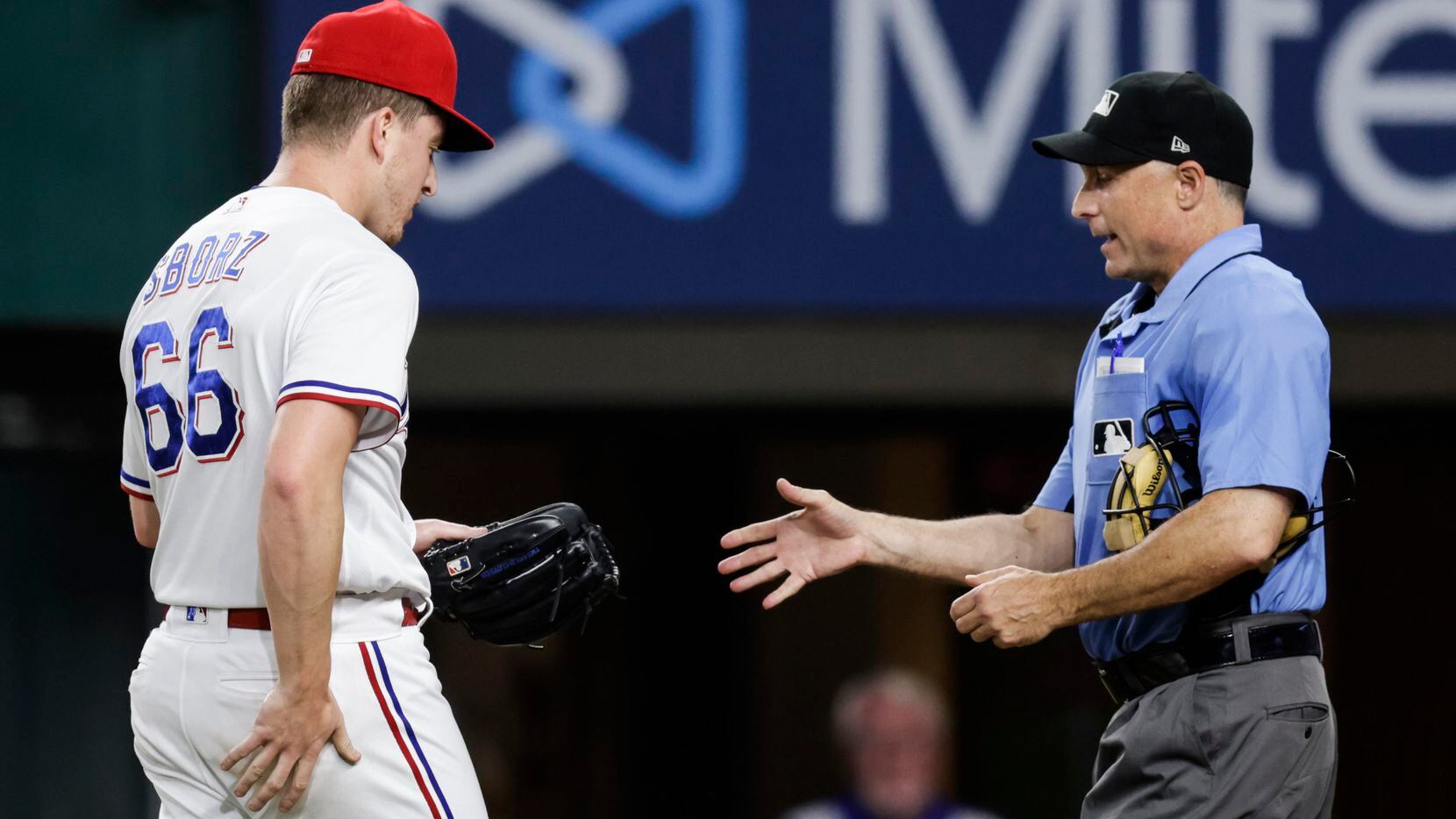 Home plate umpire Dan Iassogna inspects Texas Rangers relief pitcher Josh Sborz’s glove...