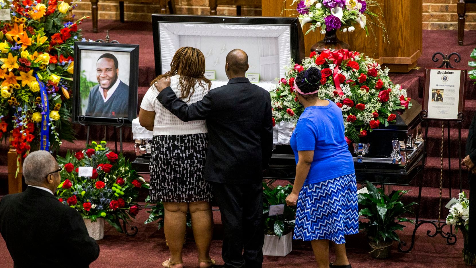 Mourners console each other during the public viewing before the funeral of Botham Shem Jean...