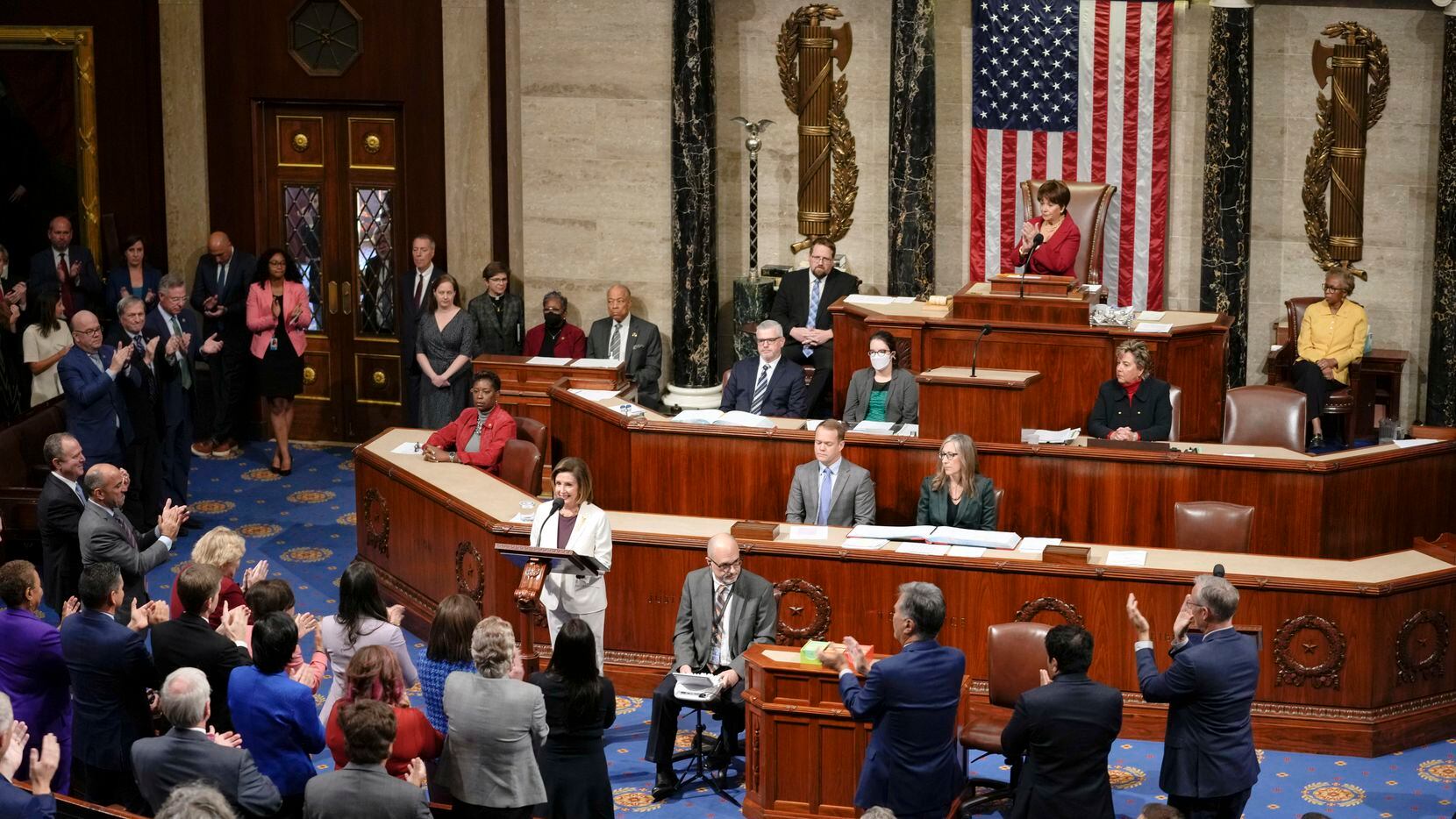 Lawmakers stand and applaud as House Speaker Nancy Pelosi of Calif., speaks on the House...