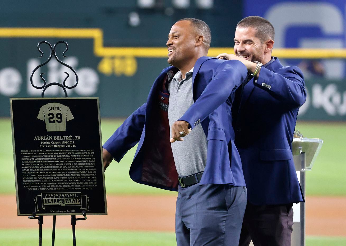 Former Texas Rangers infielders Adrian Beltre slides into the blue jacket with an assist from his presenter Michael Young during the Texas Rangers Baseball Hall of Fame induction ceremony at Globe Life Field in Arlington, Saturday, August 14, 2021. Public address announcer Chuck Morgan was also inducted. (Tom Fox/The Dallas Morning News)