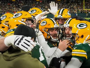 Green Bay Packers place kicker Mason Crosby (facing at right) celebrates with teammates...