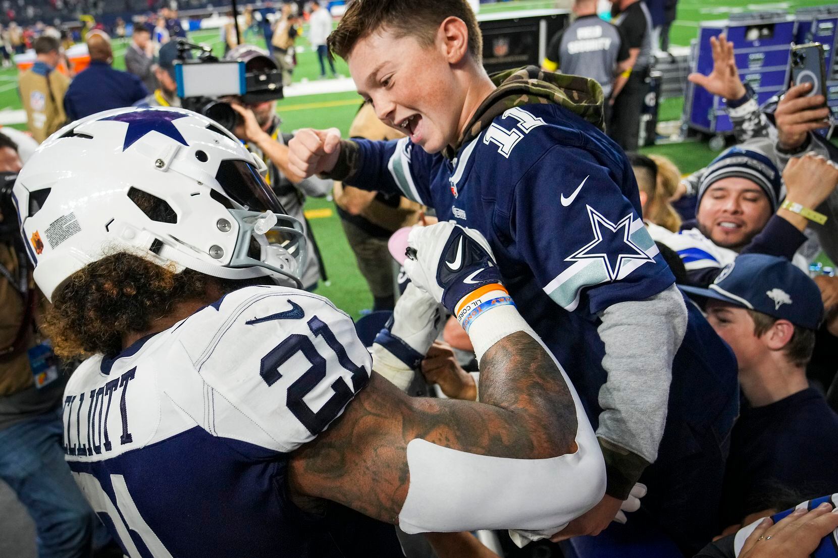Dallas Cowboys running back Ezekiel Elliott autographs a fan’s jersey after a 28-20 victory...