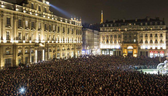 Miles de personas se reúnen en Lyon, Francia, para prestar un momento de silencio en honor a...