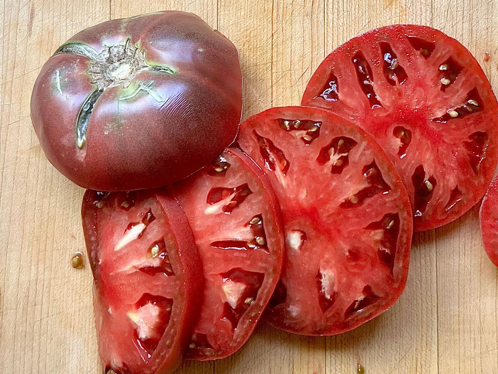 Purple-red tomatoes are sliced open.