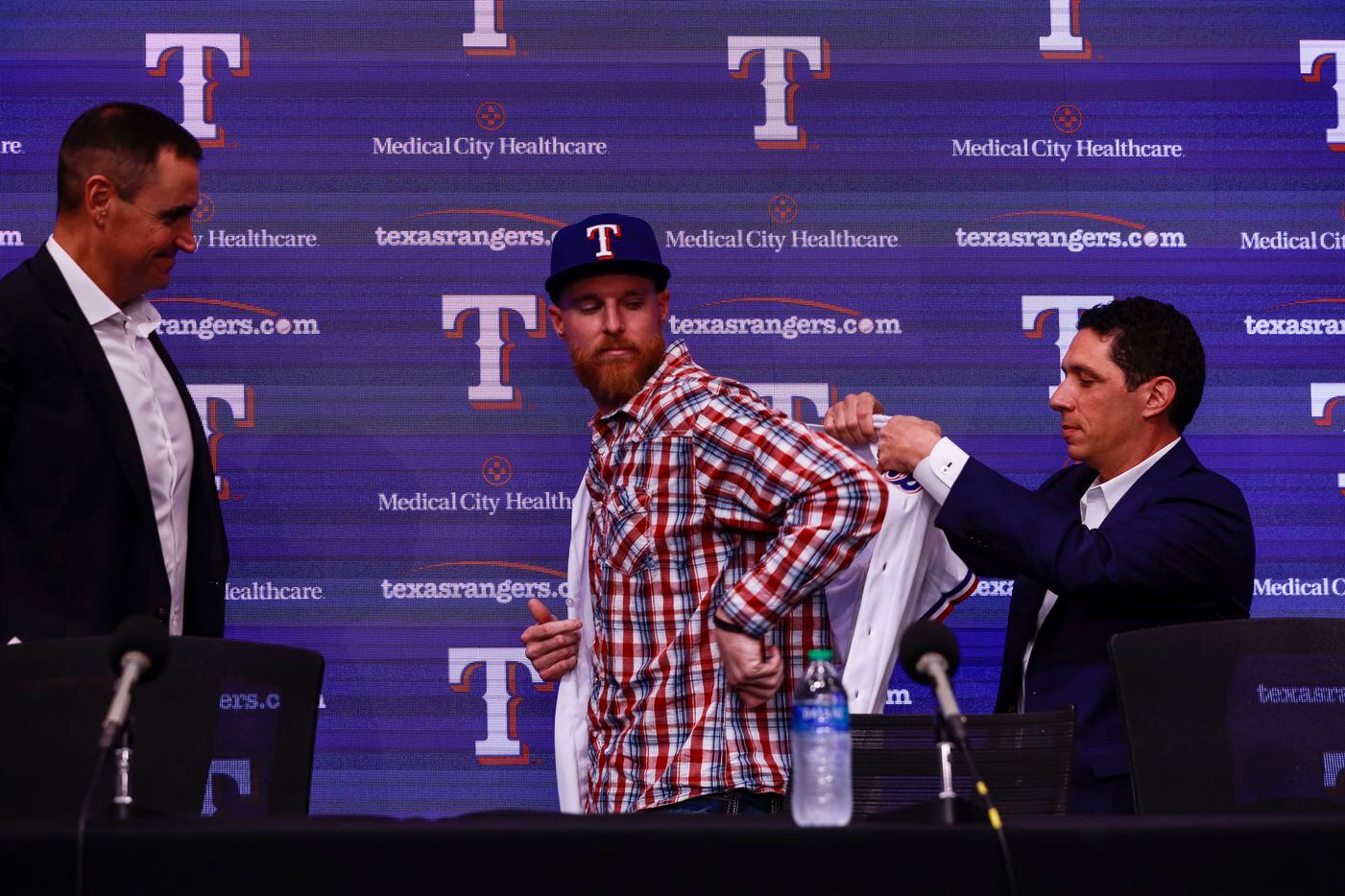 Jon Gray puts on his baseball jersey at a news conference at Globe Life Park in Arlington on Wednesday, Dec. 1, 2021. Former Colorado Rockies pitcher, Jon Gray, signed with the Texas Rangers for 56 million dollars. (Rebecca Slezak/The Dallas Morning News)