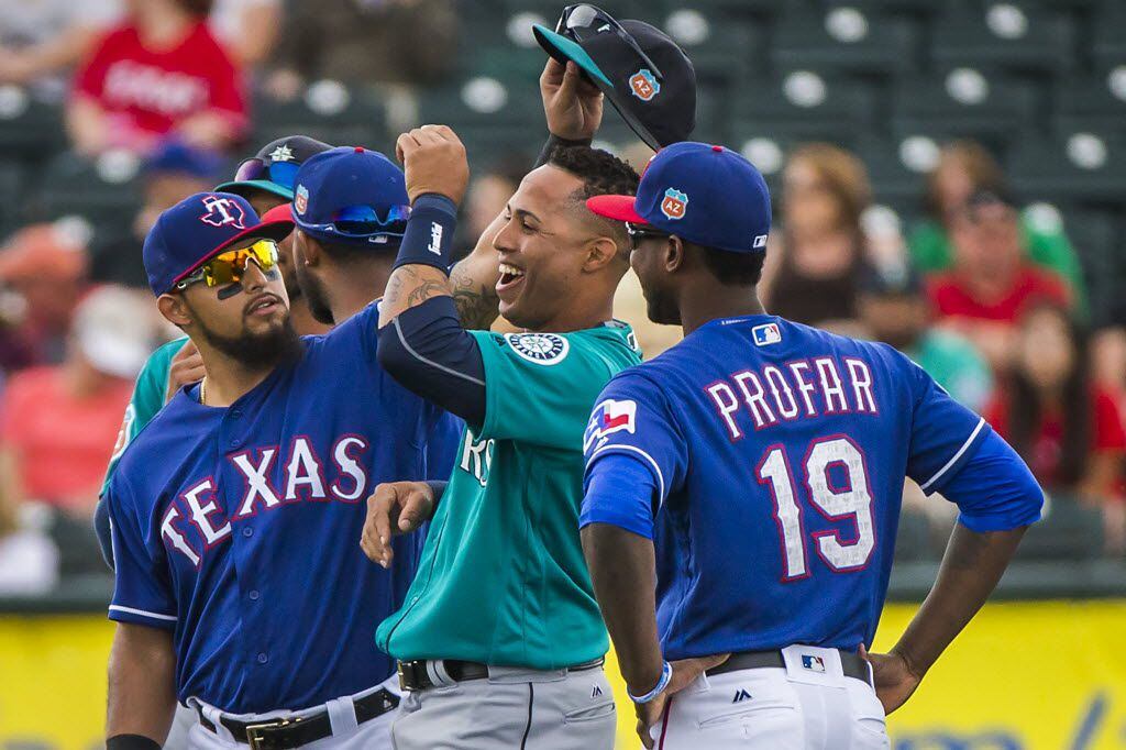 Texas Rangers second baseman Rougned Odor lifts the cap of Seattle Mariners center fielder...