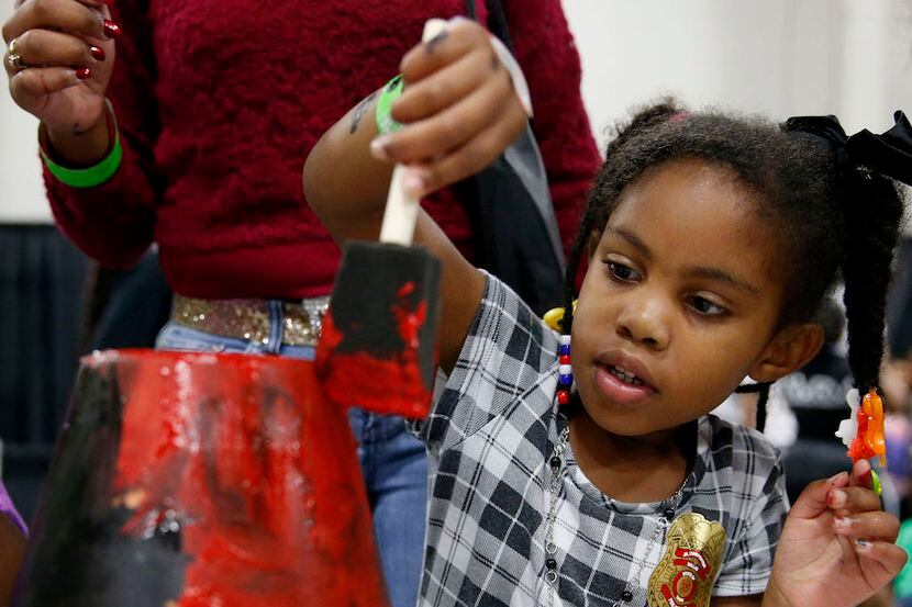 Danayjah Young, 5, of Fort Worth, paints a pot during Kwanzaa Fest.