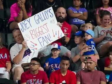 Texas Rangers fans try to get the attention of right fielder Joey Gallo during the first...
