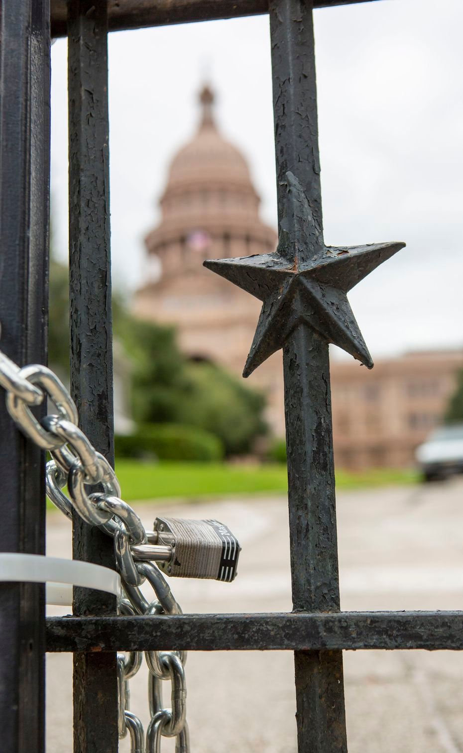 Chains and locks are seen throughout the fencing of the grounds of the Texas Capitol, such...