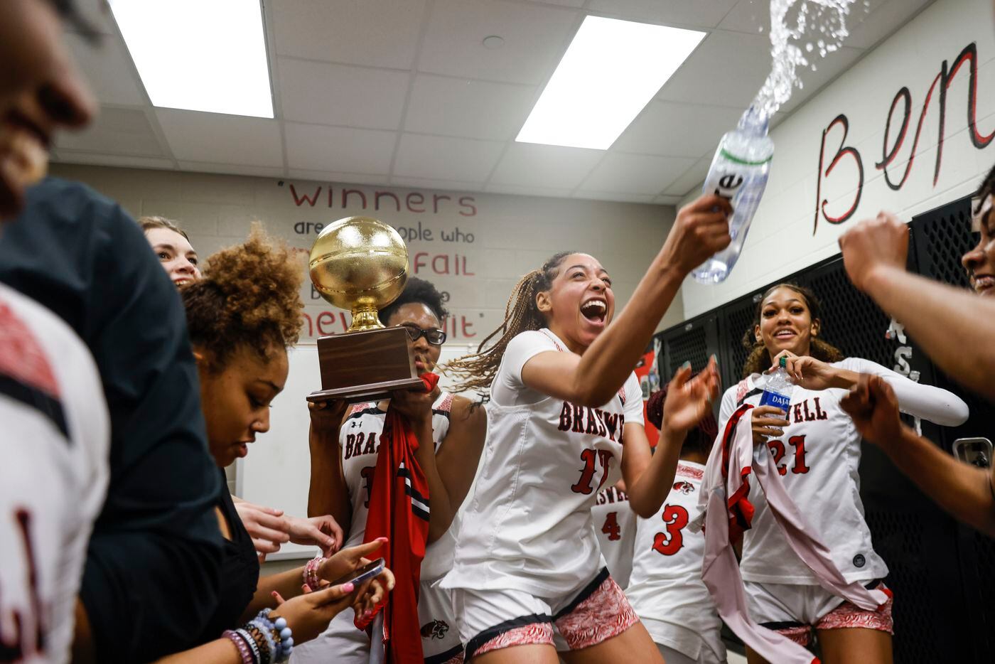 Braswell's Jazmyne Jackson, center, throws water as she cheers alongside other players...