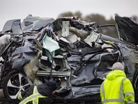 A crumpled car is towed as emergency crews work to clear the mass casualty pile-up on I-35W...
