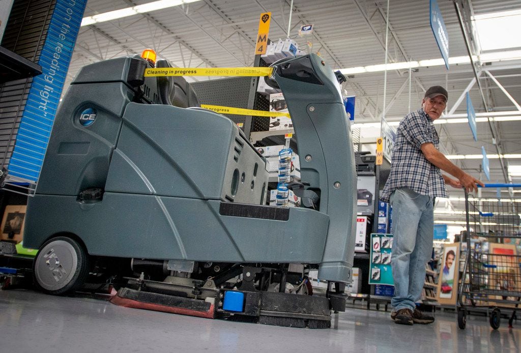 A customer watches as a robotic floor scrubber turns onto an aisle at a North Richland Hills...