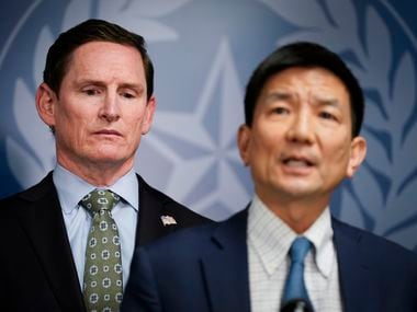 Dallas County Judge Clay Jenkins (left) listens as Dr. Philip Huang, Director of Dallas...