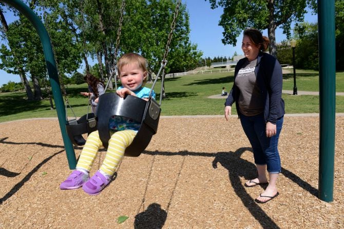 Charissa Grubbs pushes her daughter Macy in a swing at Bethany Lakes Park in Allen.