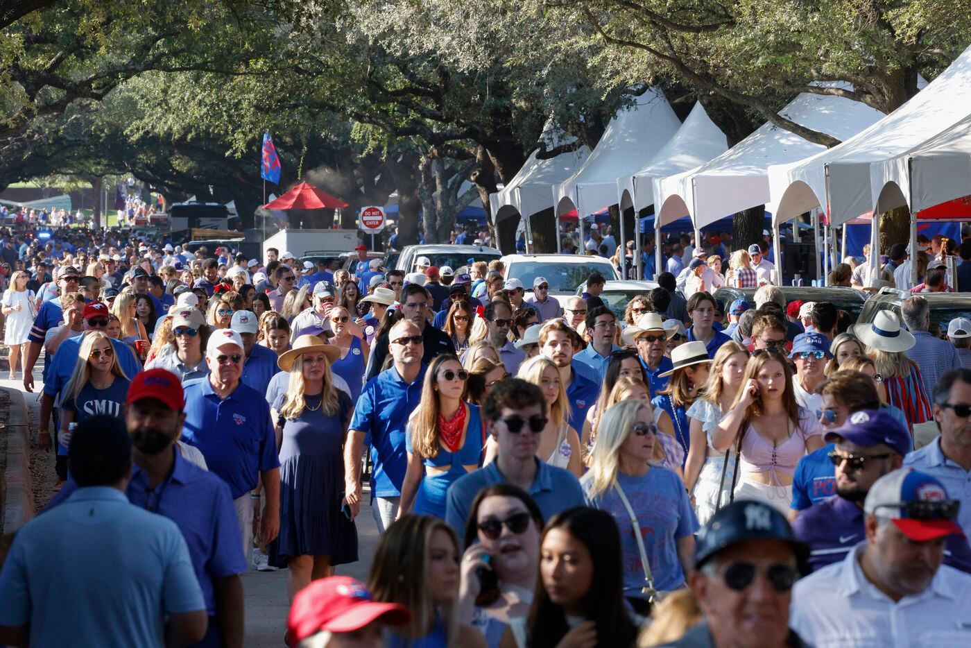 Football fans walk along Bishop Boulevard before a game between SMU and TCU at Ford Stadium,...