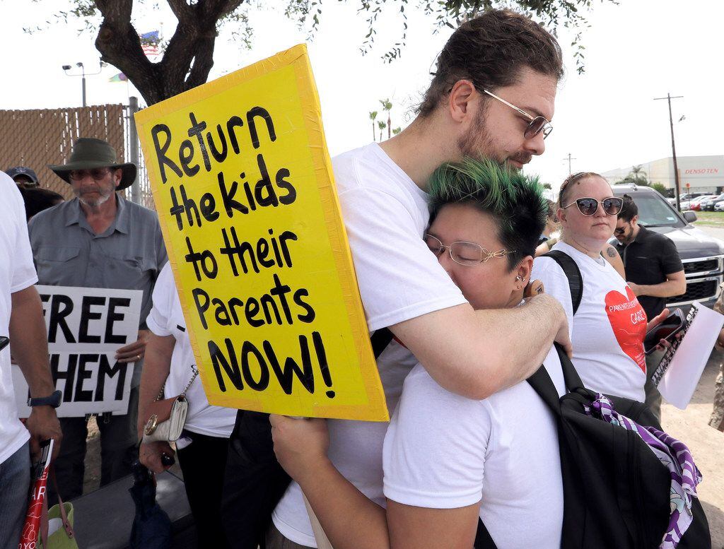 In this June 25, 2018, photo, Diana Jung Kim, right, and Homer Carroll, both from Houston, hug during a protest outside the U.S. Border Patrol Central Processing Center in McAllen, Texas. 