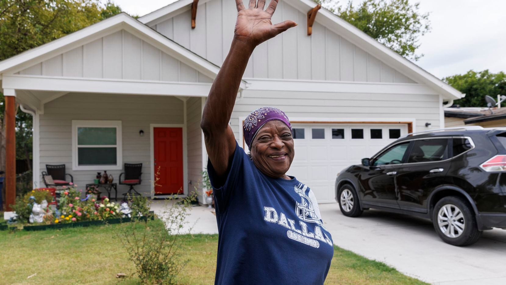 Zeta White waves to a school bus driver as she stands outside her home, Friday, Sept. 15,...