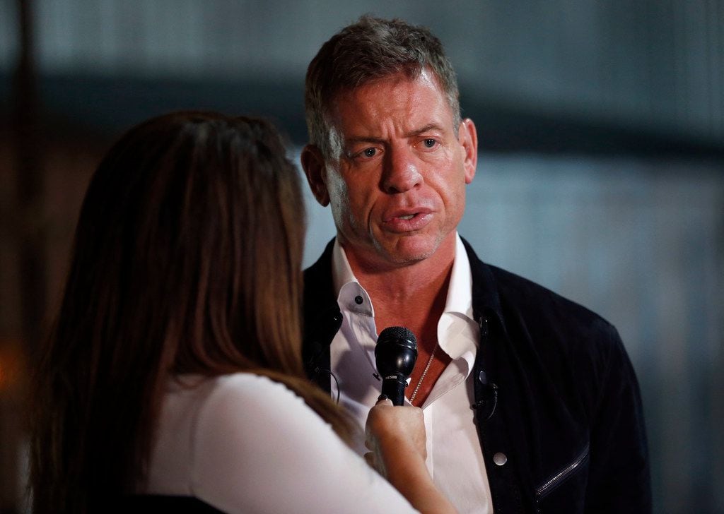 Former Dallas Cowboys quarterback Troy Aikman speaks to WFAA reporter Rebecca Lopez during...