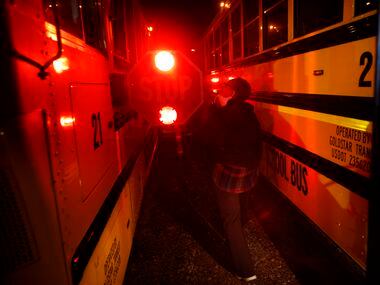 Bus driver Schrildea Glover performs an inspection on bus No. 21 before picking up students...