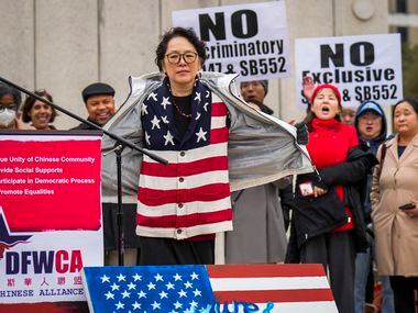 Maria Tu opens her jacket to show of an American flag themed sweater as she speaks in...