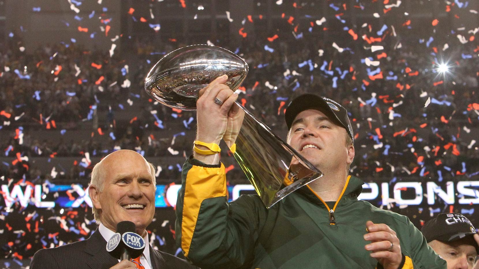 Green Bay Packers head coach Mike McCarthy admired the Lombardi Trophy as Terry Bradshaw...