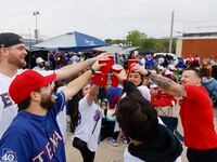 Fans including Colby Phillips (left) of Plano, cheer a drink as they tailgate before the...