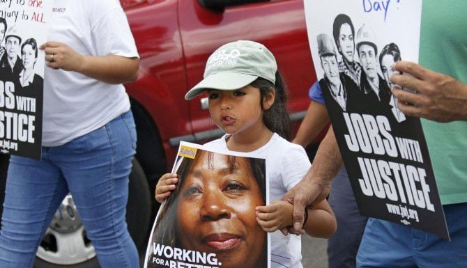 Más de 100 trabajadores y sus familias marcharon en el sur de Dallas el sábado para exigir...